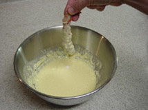 Dipping the shrimp in the tempura batter.